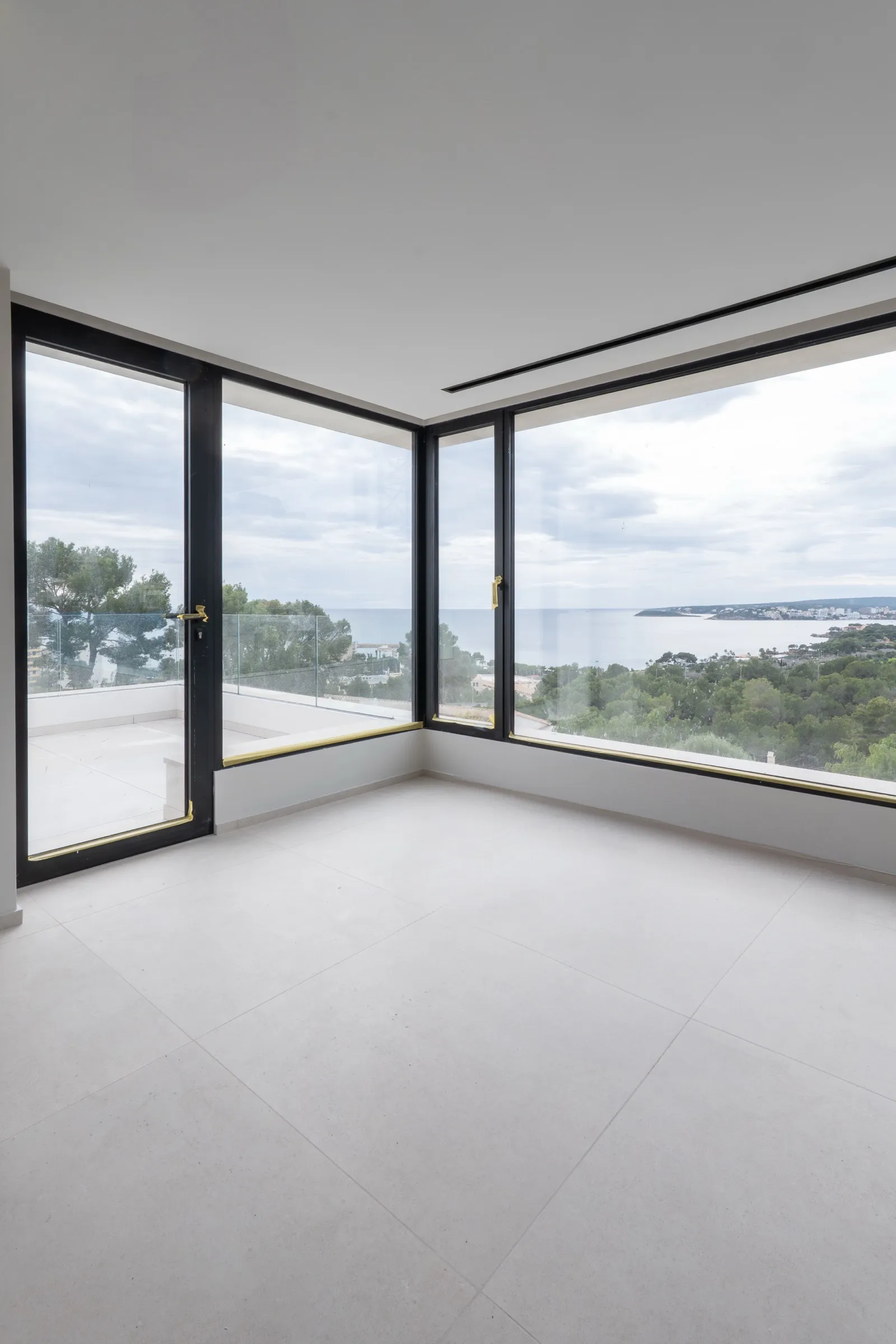 Dormitorio con falso techo continuo y ventanales panorámicos al mar en Calvià